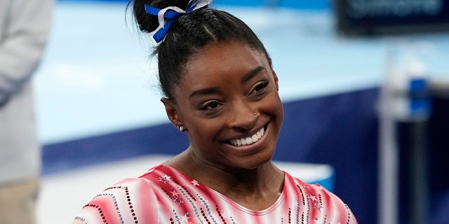 Simone Biles of the United States smiles after performing on the balance beam during the artistic gymnastics women's apparatus final at the 2020 Summer Olympics Aug. 3, 2021, in Tokyo. 