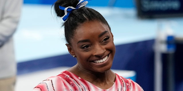 Simone Biles de los Estados Unidos sonríe después de actuar en la barra de equilibrio en la final del aparato femenino de gimnasia artística en los Juegos Olímpicos de Verano de 2020 el 3 de agosto de 2021 en Tokio. 