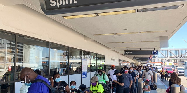 Passengers line up outside the Spirit Airlines terminal at Los Angeles International Airport in Los Angeles on Tuesday, Aug. 3, 2021. 