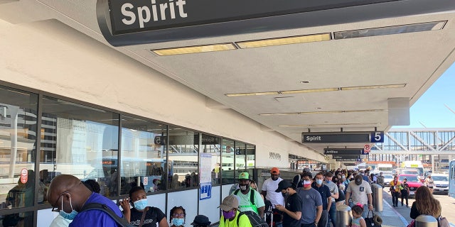 Passengers line up outside the Spirit Airlines terminal at Los Angeles International Airport in Los Angeles on Tuesday, Aug. 3, 2021. 