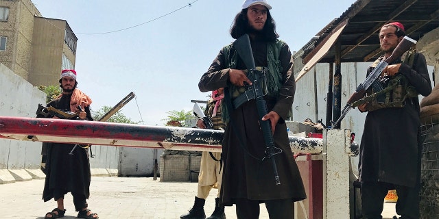 Taliban fighters stand guard at a checkpoint near the US embassy that was previously manned by American troops, in Kabul, Afghanistan, Tuesday, Aug. 17, 2021.