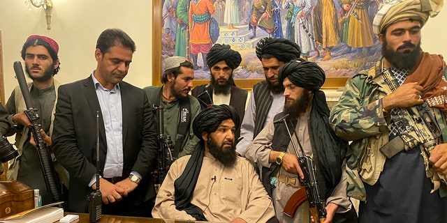 Taliban fighters take control of Afghan presidential palace after the Afghan President Ashraf Ghani fled the country, in Kabul, Afghanistan, Sunday, Aug. 15, 2021. Person second from left is a former bodyguard for Ghani. (AP Photo/Zabi Karimi)