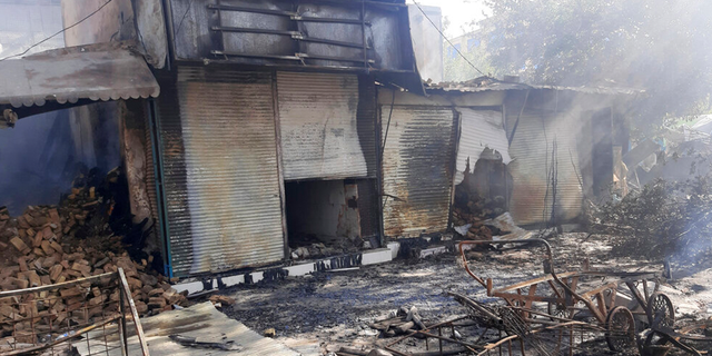 Smoke rises from damaged shops after fighting between Taliban and Afghan security forces in Kunduz city, northern Afghanistan, Sunday, Aug. 8, 2021. 