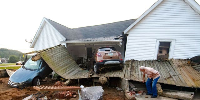 Ernest Hollis looks for items at his granddaughter's house that was devastated by floodwaters, Monday, Aug. 23, 2021, in Waverly, Tenn.
