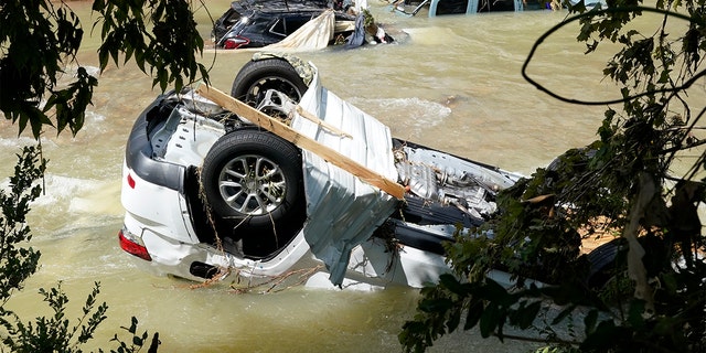 Vehicles come to rest in a stream Sunday, Aug. 22, 2021, in Waverly, Tennessee. (Associated Press)