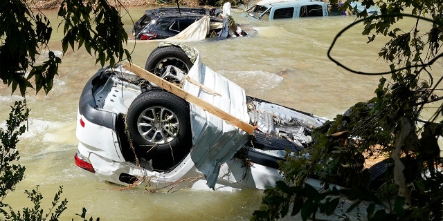 Vehicles come to rest in a stream Sunday, Aug. 22, 2021, in Waverly, Tennessee. (Associated Press)