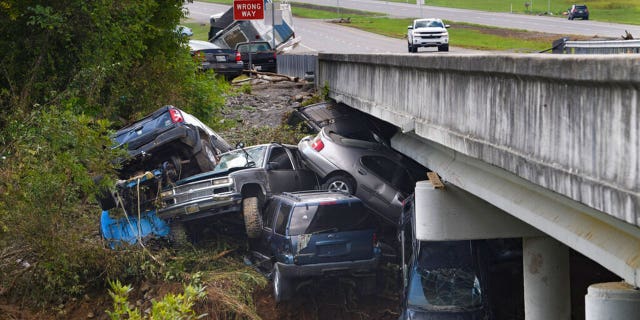 Cars are stacked on top of each other on the banks of Blue Creek being swept up in flood water, Monday, Aug. 23, 2021, in Waverly, Tenn. Heavy rains caused flooding in Middle Tennessee days ago and have resulted in multiple deaths as homes and rural roads were washed away.