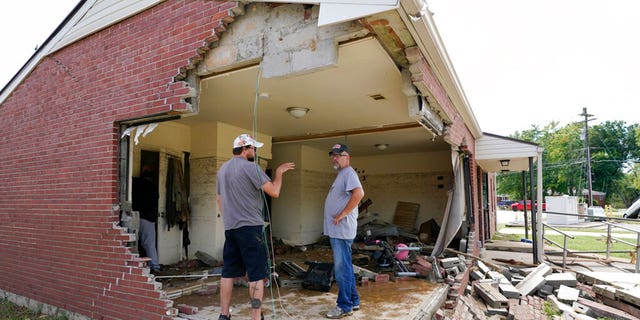 Brian Mitchell, right, looks through the damaged home of his mother-in-law along with family friend Chris Hoover, left, Sunday, Aug. 22, 2021, in Waverly, Tenn. Heavy rains caused flooding Saturday in Middle Tennessee and have resulted in multiple deaths as homes and rural roads were washed away. 