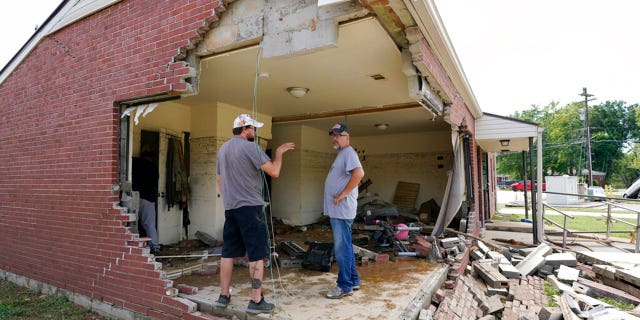 Brian Mitchell, right, looks through the damaged home of his mother-in-law along with family friend Chris Hoover, left, Sunday, Aug. 22, 2021, in Waverly, Tenn. Heavy rains caused flooding Saturday in Middle Tennessee and have resulted in multiple deaths as homes and rural roads were washed away.