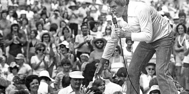Tom T. Hall leans to the edge of the stage at the 1977 Jamboree in the Hills to meet the people near St. Clairsville, Ohio. (Associated Press)