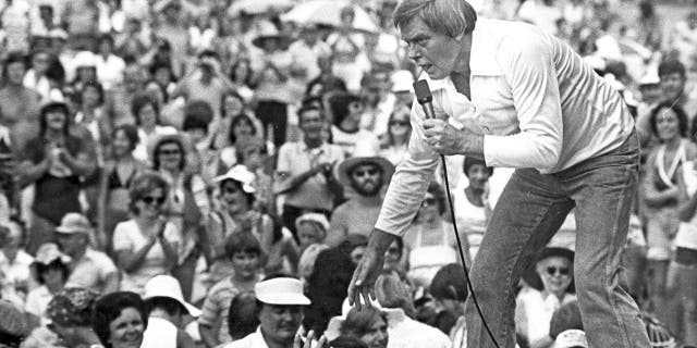 Tom T-Hall si sporge sul bordo del palco in un accampamento del 1977 sulle colline per incontrare persone vicino a St. Clairsville, Ohio.  (Agenzia di stampa)