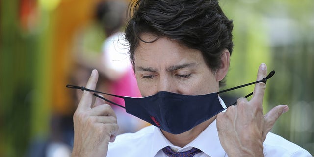 Justin Trudeau, Canada's prime minister, takes his protective mask off during a news conference on child care in Montreal, Quebec, Canada, on Thursday, Aug. 5, 2021. Trudeau will likely call a snap election for September as the pandemic has turned into an opportunity for him to slay a very personal dragon: appear less movie star and more ship captain. Photographer: Christinne Muschi/Bloomberg via Getty Images