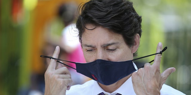 Canadian Prime Minister Justin Trudeau takes his protective mask off during a news conference on child care in Montreal, Quebec, Canada, on Thursday, Aug. 5, 2021. (Christinne Muschi/Bloomberg via Getty Images)