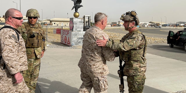 U.S. Marine Corps Gen. Frank McKenzie, center, the commander of U.S. Central Command, meets with U.S. Navy Rear Adm. Peter Vasely, commander of U.S. Forces Afghanistan-Forward, at Hamid Karzai International Airport, Kabul, Afghanistan, Tuesday, Aug. 17, 2021. (Capt. William Urban/U.S. Navy via AP)