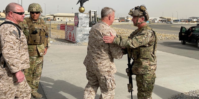 U.S. Marine Corps Gen. Frank McKenzie, center, the commander of U.S. Central Command, meets with U.S. Navy Rear Adm. Peter Vasely, commander of U.S. Forces Afghanistan-Forward, at Hamid Karzai International Airport, Kabul, Afghanistan, Tuesday, Aug. 17, 2021. (Capt. William Urban/U.S. Navy via AP)