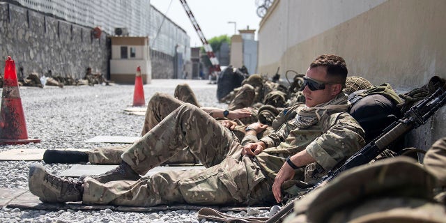 In this photo issued by Britain's Ministry of Defence (MoD), showing members of UK Armed Forces who are working to evacuate entitled personnel from Afghanistan's Kabul airport, Monday Aug. 23, 2021.  Defence Secretary Ben Wallace has said the Kabul evacuation effort is "down to hours now, not weeks" as he conceded Britain's involvement will end when the US leaves Afghanistan.  (LPhot Ben Shread/MoD via AP)