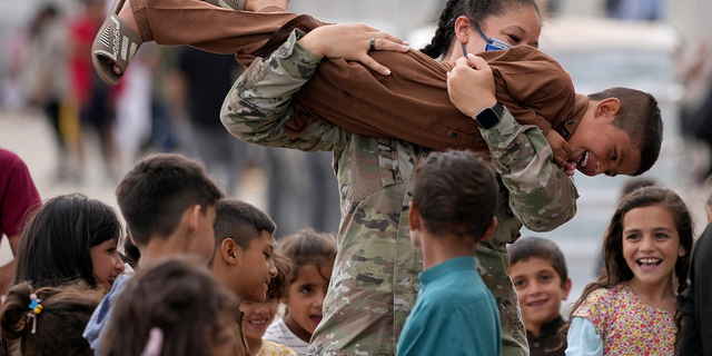 An U.S. soldier plays with recently evacuated Afghan children.