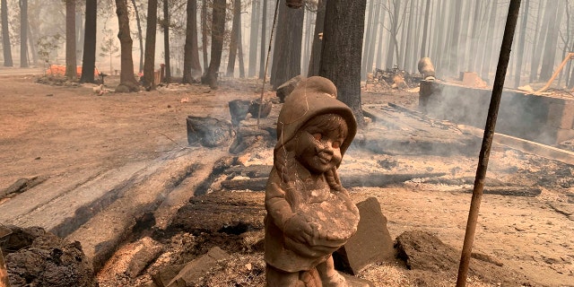 A surviving ceramic statue is seen outside a house that burned along North Arm Road in Plumas County near Taylorsville, Calif., on Sunday. (AP Photo/Eugene Garcia)