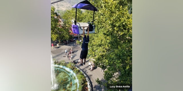 A witness recorded cellphone video of the man dangling from the chair of the park's Sky Ride.
