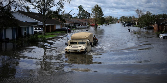 A National Guard vehicle drives through floodwater left behind by Hurricane Ida in LaPlace, Louisiana, on Monday, Aug. 30, 2021. The storm, wielding some of the most powerful winds ever to hit the state, drove a wall of water inland when it thundered ashore Sunday as a Category 4 hurricane and reversed the course of part of the Mississippi River. 