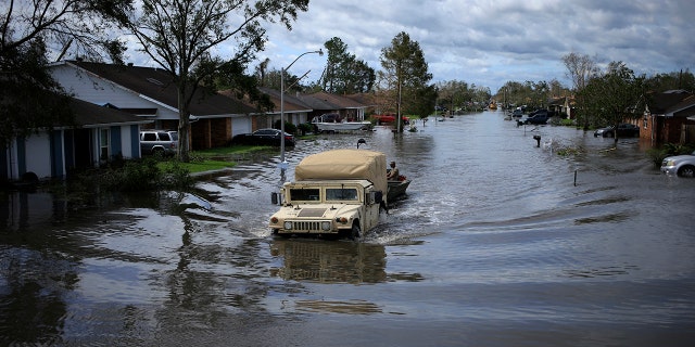 A National Guard vehicle drives through floodwater left behind by Hurricane Ida in LaPlace, Louisiana, on Monday, Aug. 30, 2021. The storm, wielding some of the most powerful winds ever to hit the state, drove a wall of water inland when it thundered ashore Sunday as a Category 4 hurricane and reversed the course of part of the Mississippi River.