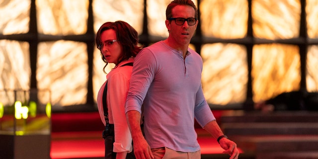 This image released by 20th Century Studios shows Jodie Comer (L) and Ryan Reynolds (R) in a scene from 'Free Guy.'