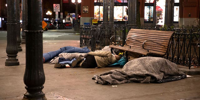 People sleep outside on a sidewalk on April 6, 2020, in Seattle. 