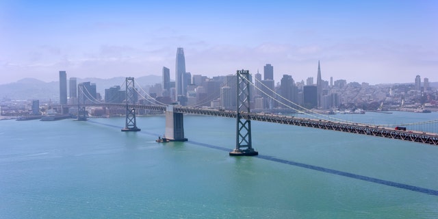 Aerial view of the San Francisco-Oakland Bay Bridge with modern cityscape in background, San Francisco, California, USA.