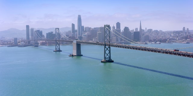 Aerial view of the San Francisco-Oakland Bay Bridge with modern cityscape in background, San Francisco, California, USA.