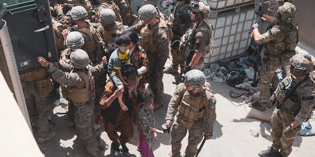 (August 20, 2021) U.S. Marines and Norweigian coalition forces assist with security at an Evacuation Control Checkpoint ensuring evacuees are processed safely during an evacuation at Hamid Karzai International Airport, Kabul, Afghanistan, Aug. 20. U.S. service members are assisting the Department of State with a non-combatant evacuation operation (NEO) in Afghanistan. (U.S. Marine Corps photo by Staff Sgt. Victor Mancilla)