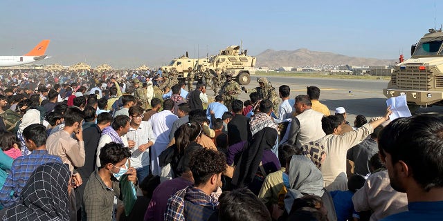 U.S soldiers stand guard along a perimeter at the international airport in Kabul, Afghanistan, Monday, Aug. 16, 2021. 