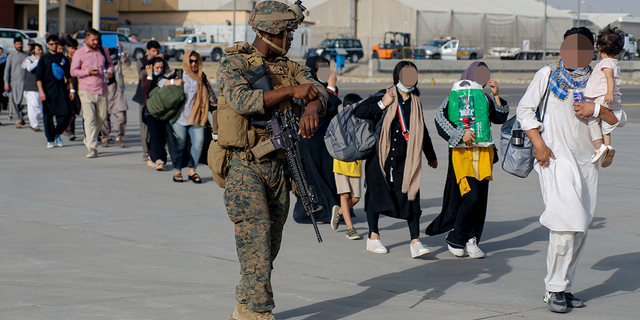 Biden administration's Afghanistan withdrawal caused major frustration across US military, Army report reveals 5 US Marines assigned to 24th Marine Expeditionary Unit escorts evacuees during an evacuation at Hamid Karzai International Airport, Afghanistan, Aug. 18.