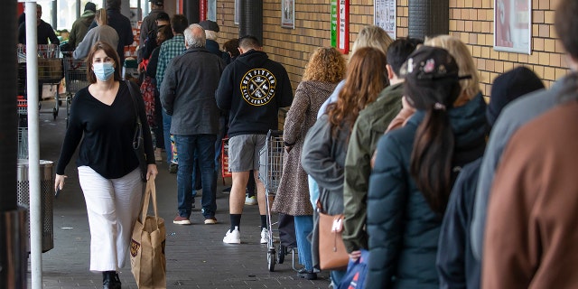 Shoppers lineup to enter a supermarket in Auckland, New Zealand, Tuesday, Aug. 17, 2021. New Zealand's government took drastic action Tuesday by putting the entire nation into a strict lockdown after detecting just a single community case of the coronavirus. (Brett Phibbs/New Zealand Herald via AP)