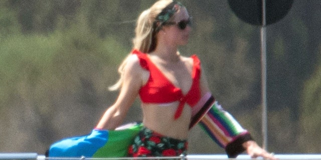 Paris Hilton sported a high-waisted red and floral bikini and sported a striped coverup on a luxurious yacht. 