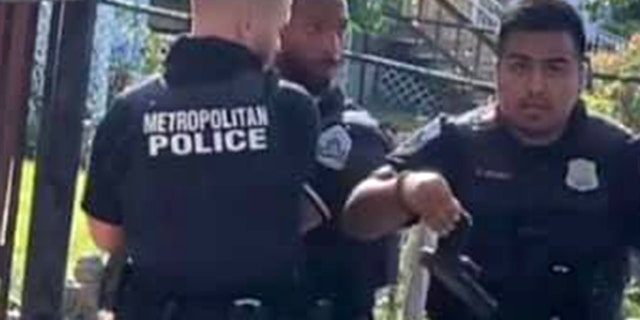 Bystander video shows an officer holding the handgun recovered from a suspect’s waistband. Earlier in the viral clip, two officers are seen restraining the suspect, as a third officer was punching him in the face.