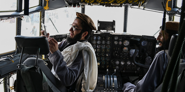 TOPSHOT - Taliban fighters sit in the cockpit of an Afghan Air Force aircraft at the airport in Kabul on August 31, 2021, after the US has pulled all its troops out of the country to end a brutal 20-year war -- one that started and ended with the hardline Islamist in power. (Photo by Wakil KOHSAR / AFP) (Photo by WAKIL KOHSAR/AFP via Getty Images)