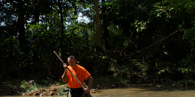 Dustin Shadownes, of the Ashland City Fire Department, searches for a creek for missing persons, Monday, August 23, 2021, in Waverly, Tennessee.  Heavy rains caused flooding in central Tennessee days earlier and left several dead, missing people and destroyed property.