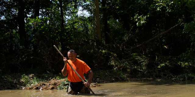 Dustin Shadownes, of Ashland City Fire Department, searches a creek for missing persons, Monday, Aug. 23, 2021, in Waverly, Tenn. Heavy rains caused flooding in Middle Tennessee days earlier and have resulting in multiple deaths, missing persons, and property destroyed.