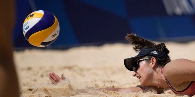 Sarah Sponcil, of the United States, dives for the ball during a women's beach volleyball match against Canada at the 2020 Summer Olympics, Sunday, Aug. 1, 2021, in Tokyo. (Associated Press)