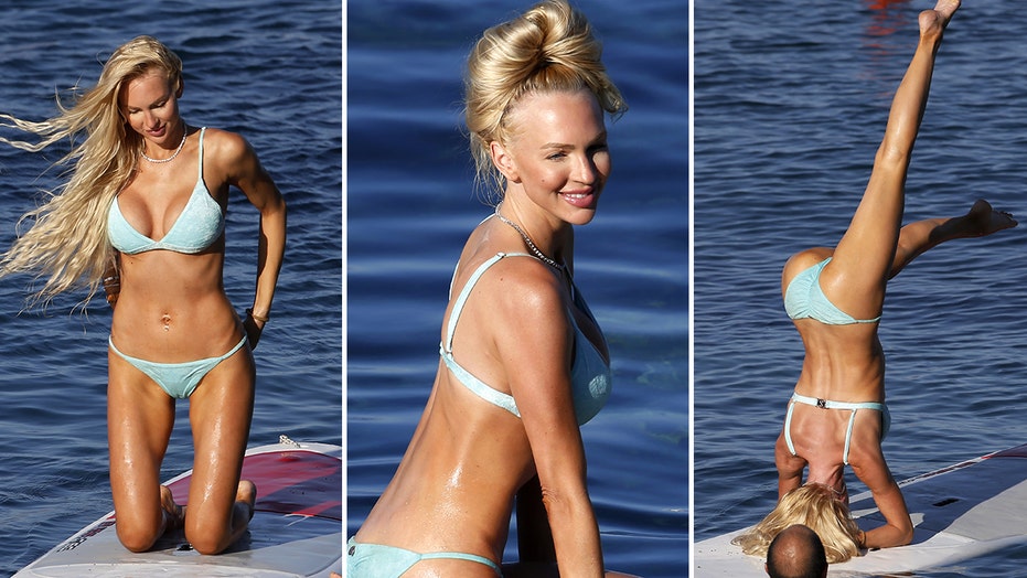 Christine Quinn performs splits, yoga poses in tiny blue bikini on paddleboard during Italian getaway