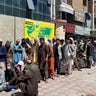 Afghans line up outside a bank to take out cash as people keep waiting at Hamid Karzai International Airport to leave the country after the Taliban's takeover in Kabul, Afghanistan, on Aug. 25, 2021. (Photo by Haroon Sabawoon/Anadolu Agency via Getty Images)