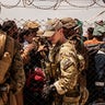 In this photo provided by the U.S. Marine Corps, U.S. service members provide assistance during an evacuation at Hamid Karzai International Airport, Kabul, Afghanistan, Sunday, Aug. 22, 2021.  (Staff Sgt. Victor Mancilla/U.S. Marine Corps via AP)