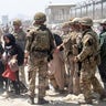 In this photo provided by the Ministry of Defence, members of the British and US military engage in the evacuation of people out of Kabul, Afghanistan on Friday, Aug. 20, 2021. (Ministry of Defence via AP)