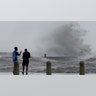 Jesse Perez, right, and Sergio Hijuelo check out the high waves on Lake Pontchartrain as Hurricane Ida nears, Sunday, Aug. 29, 2021, in New Orleans. (AP Photo/Gerald Herbert)