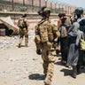 In this photo provided by the U.S. Marine Corps, Italian coalition forces assist and escort evacuees for onward processing during an evacuation at Hamid Karzai International Airport in Kabul, Afghanistan, Tuesday, Aug. 24, 2021. (Staff Sgt. Victor Mancilla/U.S. Marine Corps via AP)
