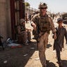 In this image provided by the U.S. Marine Corps, a U.S. Marine with the Special Purpose Marine Air-Ground Task Force-Crisis Response-Central Command escorts a child during ongoing evacuations at Hamid Karzai International Airport, Kabul, Afghanistan, Tuesday, Aug. 24, 2021. (Staff Sgt. Victor Mancilla/U.S. Marine Corps via AP)