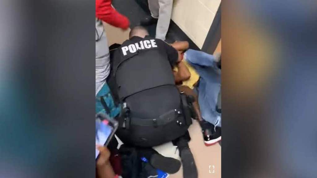 Virginia school resource officer uses body to protect child in  school brawl