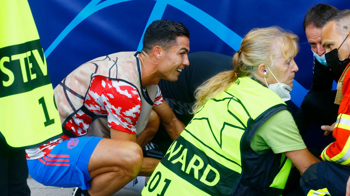 Soccer Football - Champions League - Group F - BSC Young Boys v Manchester United - Stadion Wankdorf, Bern, Switzerland- September 14, 2021 Manchester United's Cristiano Ronaldo checks on a steward after she was hit by a ball during the warm up before the match REUTERS/Arnd Wiegmann