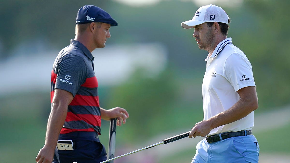Patrick Cantlay, right, walks by Bryson DeChambeau after he sank his putt on the 17th green during the final round of the BMW Championship golf tournament, Sunday, Aug. 29, 2021, at Caves Valley Golf Club in Owings Mills, Md. (AP Photo/Julio Cortez)