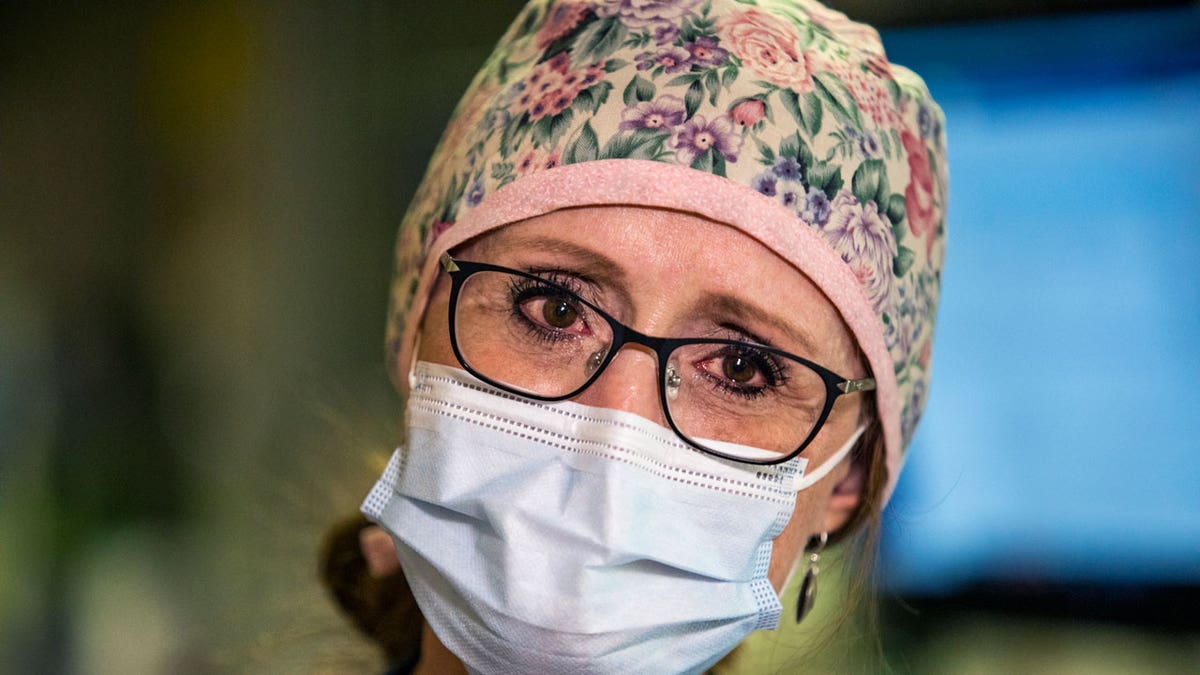 Kristen Connelly, R.N. of the Surgical intensive care unit (SICU) at St. Luke's Boise Medical Center in Boise, Idaho holds back tears as she talks about the pressure of dealing with the influx of patients to the hospital because of COVID-19 on Tuesday, Aug. 31, 2021. (AP Photo/Kyle Green)